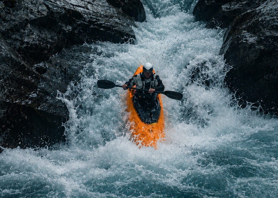 Eine Person in einem orangenen Kanu auf einen reißenden Fluss